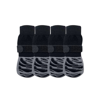 Four black anti-slip dog socks and leg warmers with rubber grips, shown on a white background.