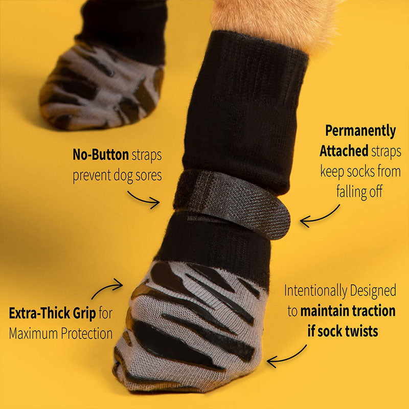 Black anti-slip dog socks and leg warmers with gray grip soles and straps on a yellow studio background.