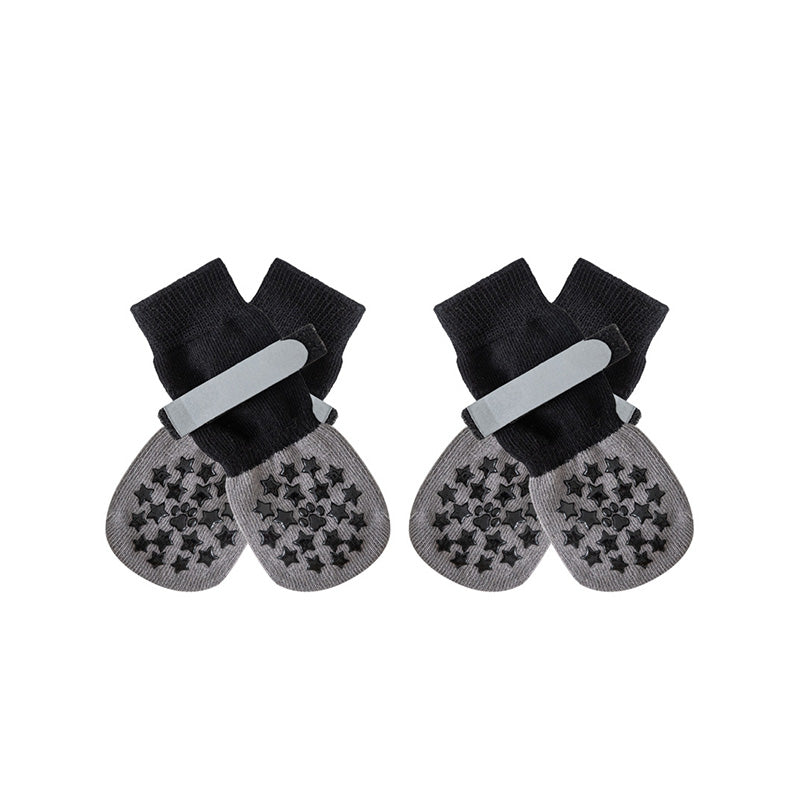 Black and gray anti-slip dog socks and leg warmers with grippy paw pads, shown in a studio shot on a white background.