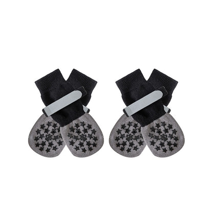 Black and gray anti-slip dog socks and leg warmers with grippy paw pads, shown in a studio shot on a white background.