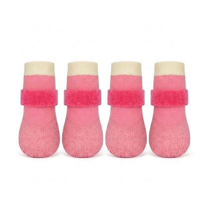 Four pink waterproof anti-slip dog socks with Velcro straps, beige cuffs, on a white studio background.