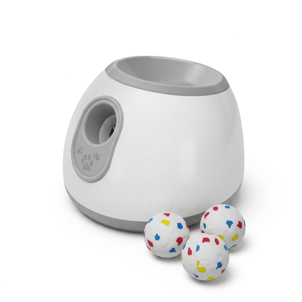 White background studio shot of a white-and-gray automatic dog ball launcher with three colorful fetch balls.