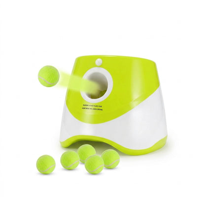 Automatic dog ball launcher on a white background, launching neon tennis balls with several balls stacked below.