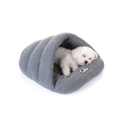Small white dog sleeping inside a heather grey fleece cave bed with hooded sleeping-bag shape.