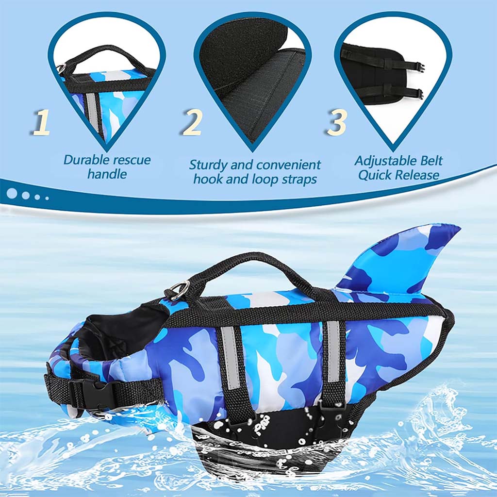 Blue camo shark fin dog life jacket swim vest with rescue handle, adjustable straps, and quick-release buckle on water background.