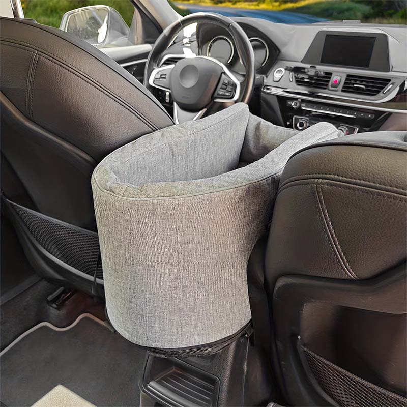 Grey pet car seat securely installed on a car's center console armrest between the driver and passenger seats.