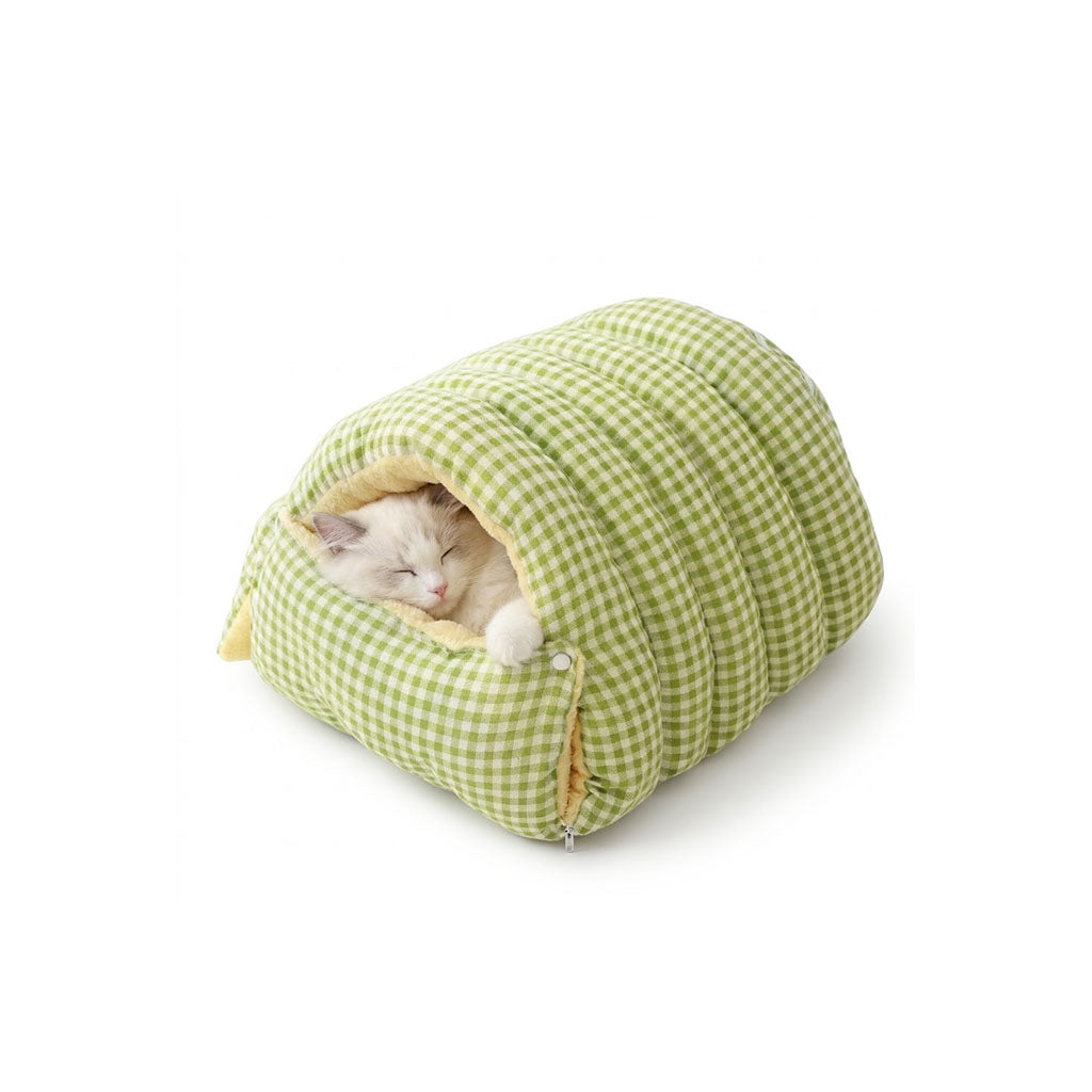 White cat sleeping inside a sage green gingham cave pet bed with plush lining.