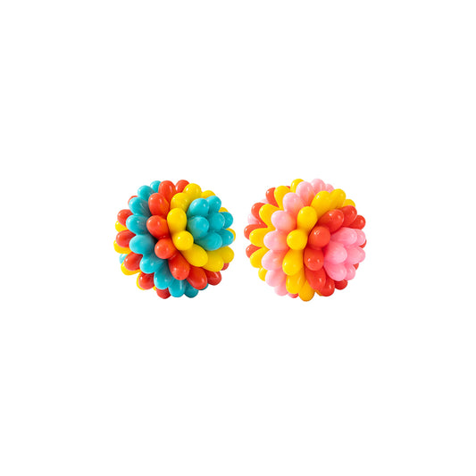 Two durable TPR rubber dog balls with spiky texture on a white background, one blue-red-yellow and one pink-yellow-red.