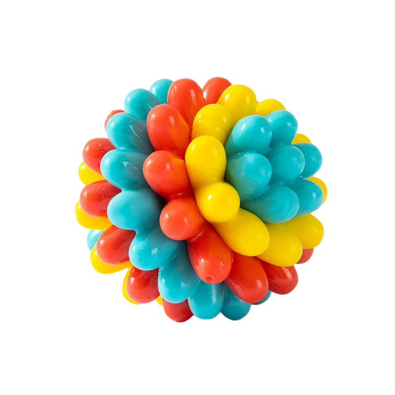 Colorful TPR rubber dog ball with blue, red, and yellow textured nubs on a white background.