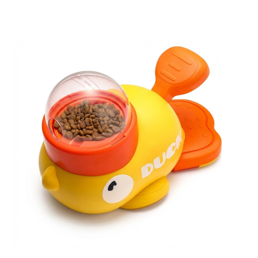 Yellow and orange interactive duck puzzle toy with a clear treat dispenser dome filled with kibble, isolated on a white background.