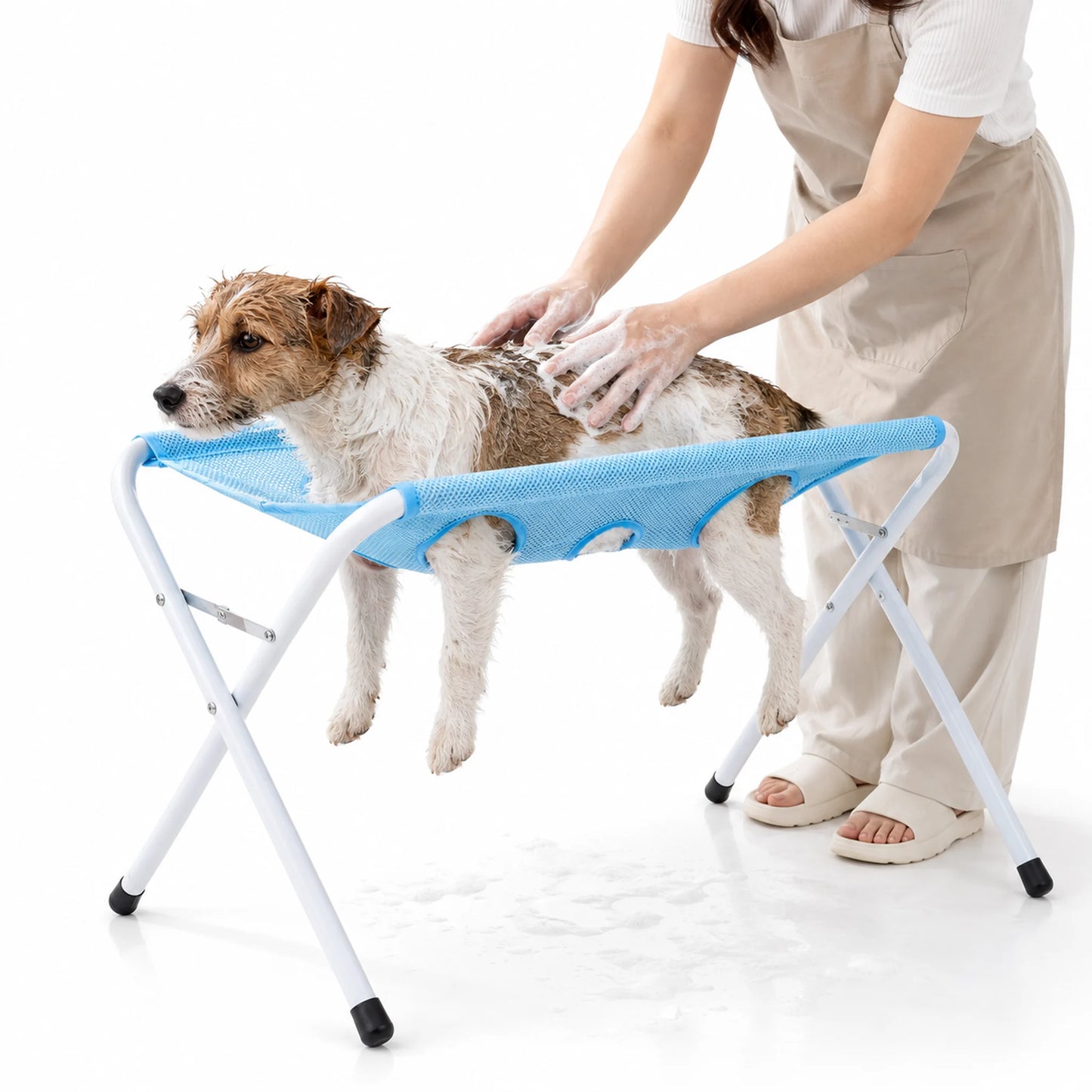Brown and white terrier being washed in a cloud blue folding pet grooming hammock stand