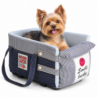 Yorkshire Terrier sitting in a denim blue center console dog car seat with a striped front pillow on white