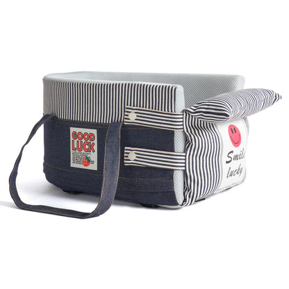 Denim blue console pet bed on white with striped removable front pillow, smile patch, side pocket and carry handles