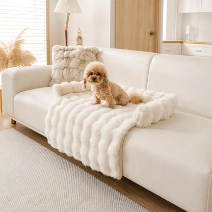 Cream faux-fur pet sofa cover with bolster on a beige couch, toy poodle lying on it