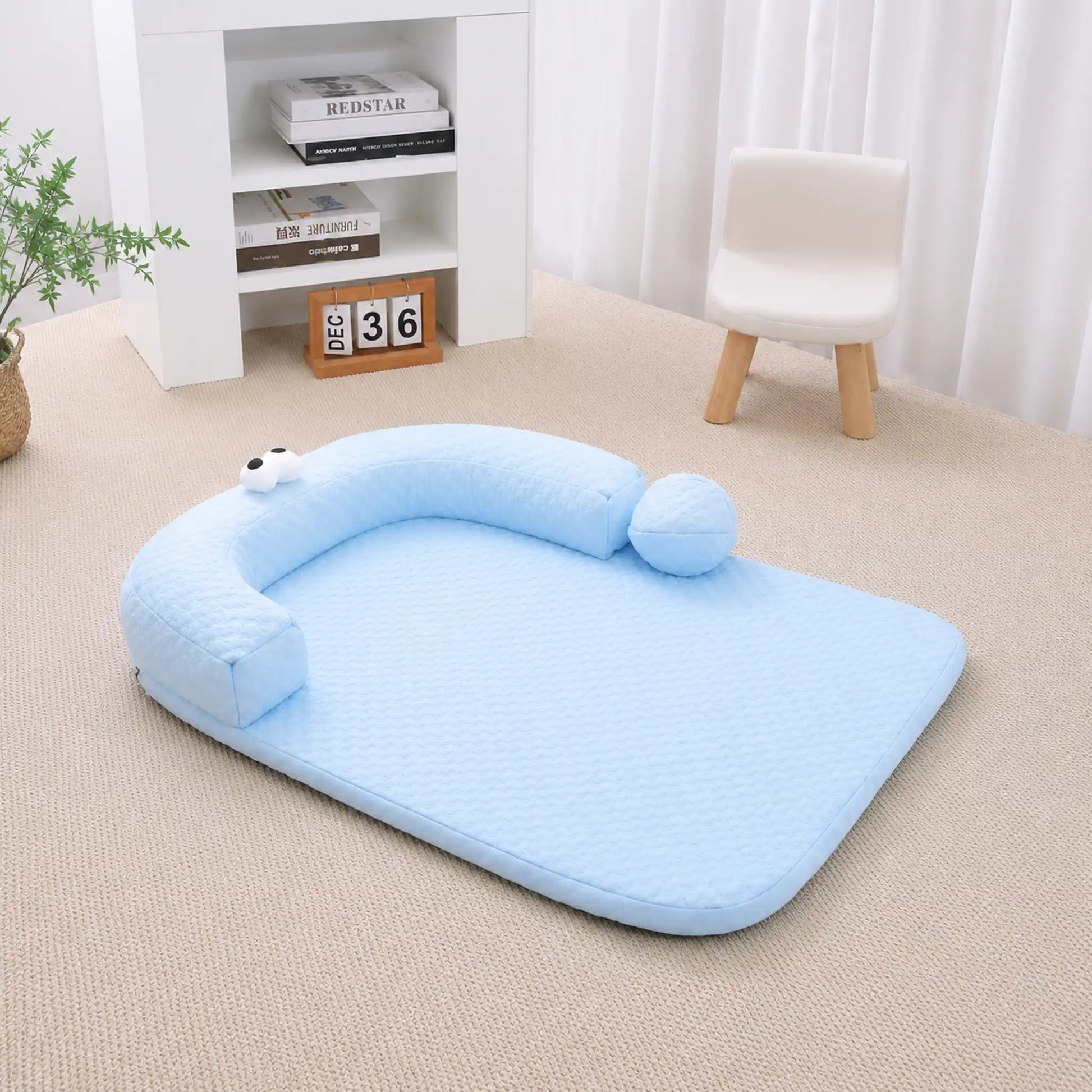 Sky-blue ice-bead cooling pet bed with C-shaped bolster on a beige carpet