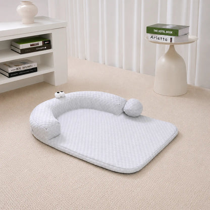 Gray ice-bead cooling pet bed with C-shaped bolster on a beige carpet