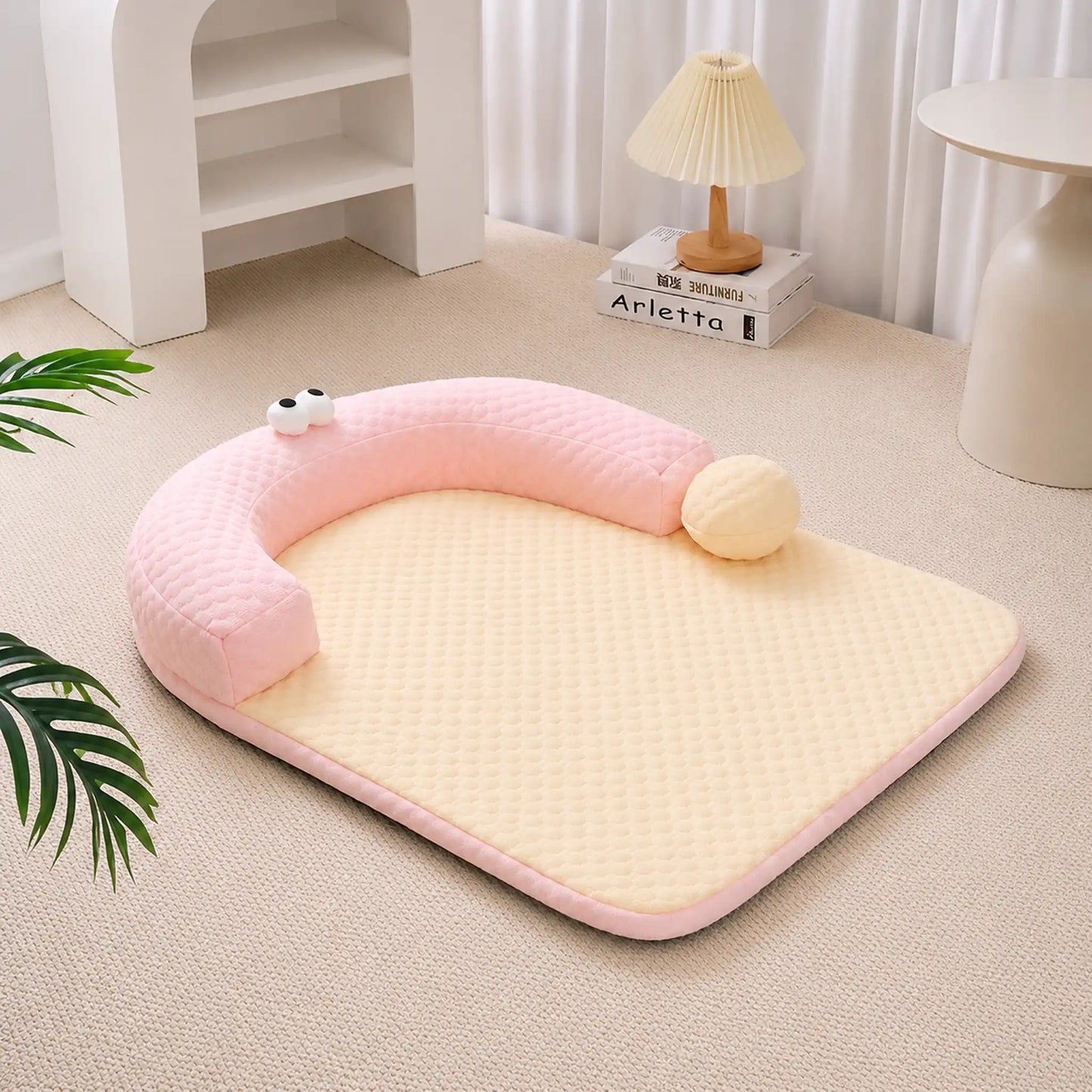 Pastel-pink ice-bead cooling pet bed with C-shaped bolster on a beige carpet