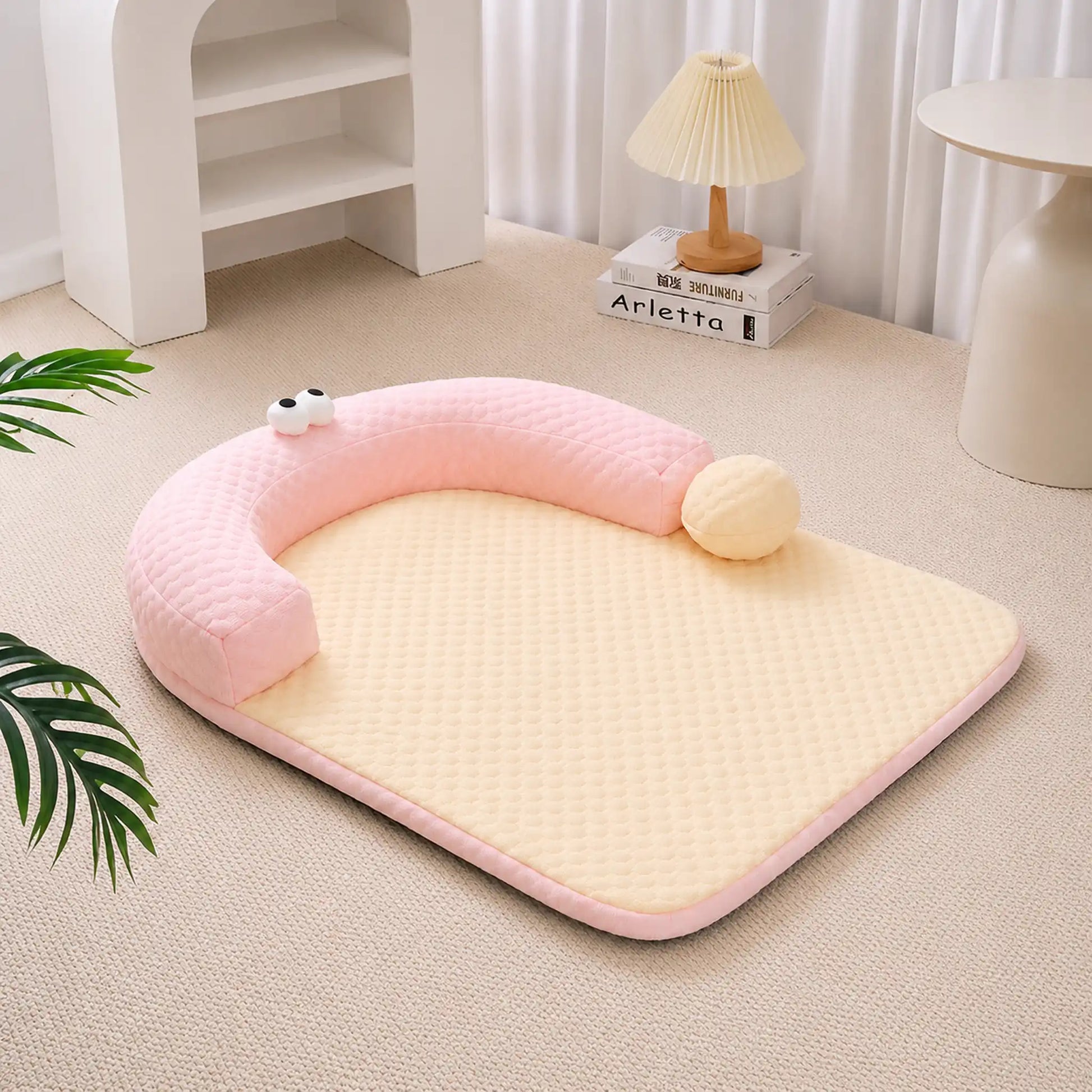 Pastel-pink ice-bead cooling pet bed with C-shaped bolster on a beige carpet