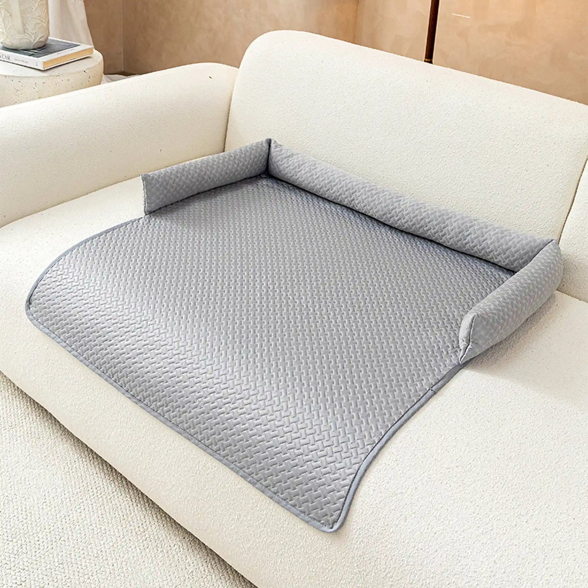 Gray ice-silk cooling pet sofa cover with C-shaped bolster on a cream boucle sofa