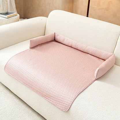 Pastel-pink ice-silk cooling pet sofa cover with C-shaped bolster on a cream boucle sofa
