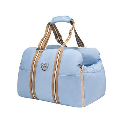 Sky-blue open-top pet carrier with padded walls, front pocket, beige zippers and striped adjustable handles.