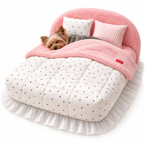 Yorkshire Terrier sleeping under the quilt of a pink plush pet bed with a white polka-dot cover and two pillows.