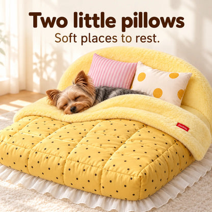 Yorkshire Terrier resting in the yellow plush pet bed beside its two small patterned pillows.