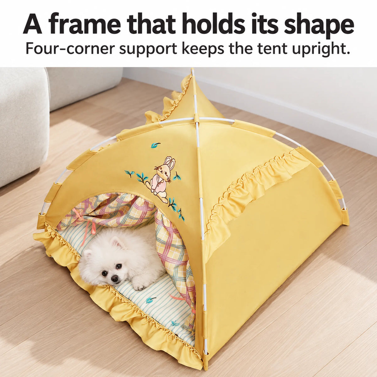Overhead view of the yellow bunny tent frame with a white Pomeranian resting inside