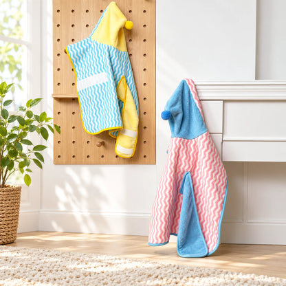 Pink and blue and blue and yellow pet bathrobes hanging in a bright home