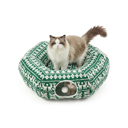 Winter Green Reindeer variant — Ragdoll cat standing on top of the forest-green donut bed patterned with white reindeer and trees.