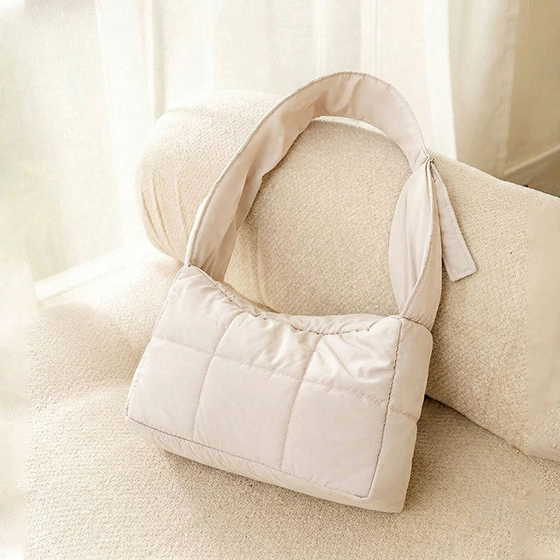 Khaki quilted winter cat sling carrier product shot on a cream sofa.