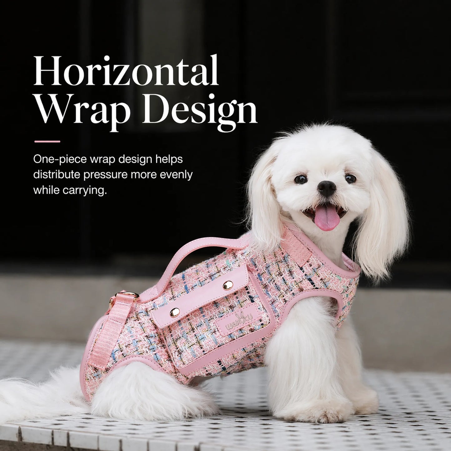 Small white dog wearing pink tweed dog carrier harness showing the horizontal one-piece wrap design with top handle