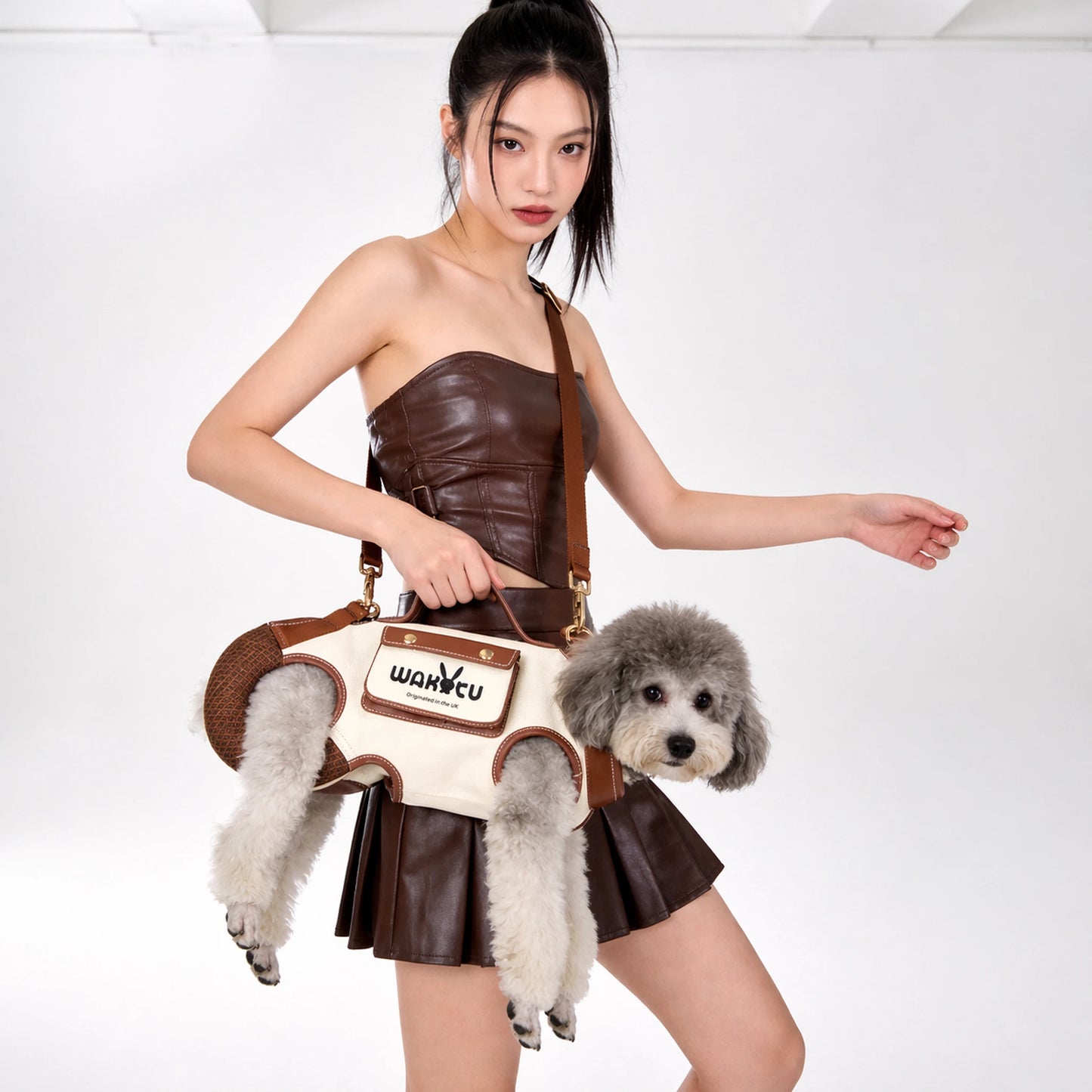 Fashion lifestyle shot of a woman carrying a white poodle in the cream dog carrier harness bag
