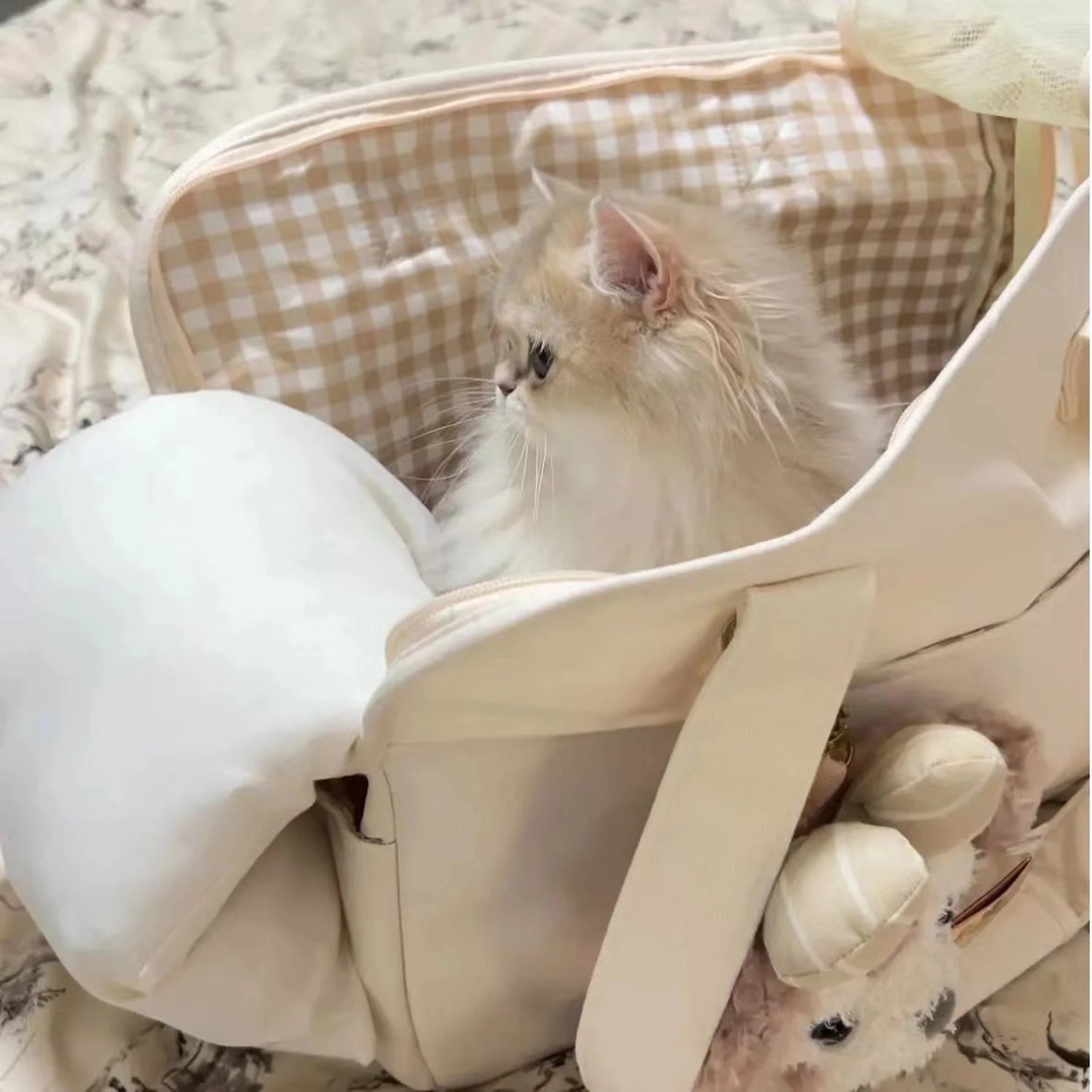 Pet carrier used as cat bed at home with gingham lining