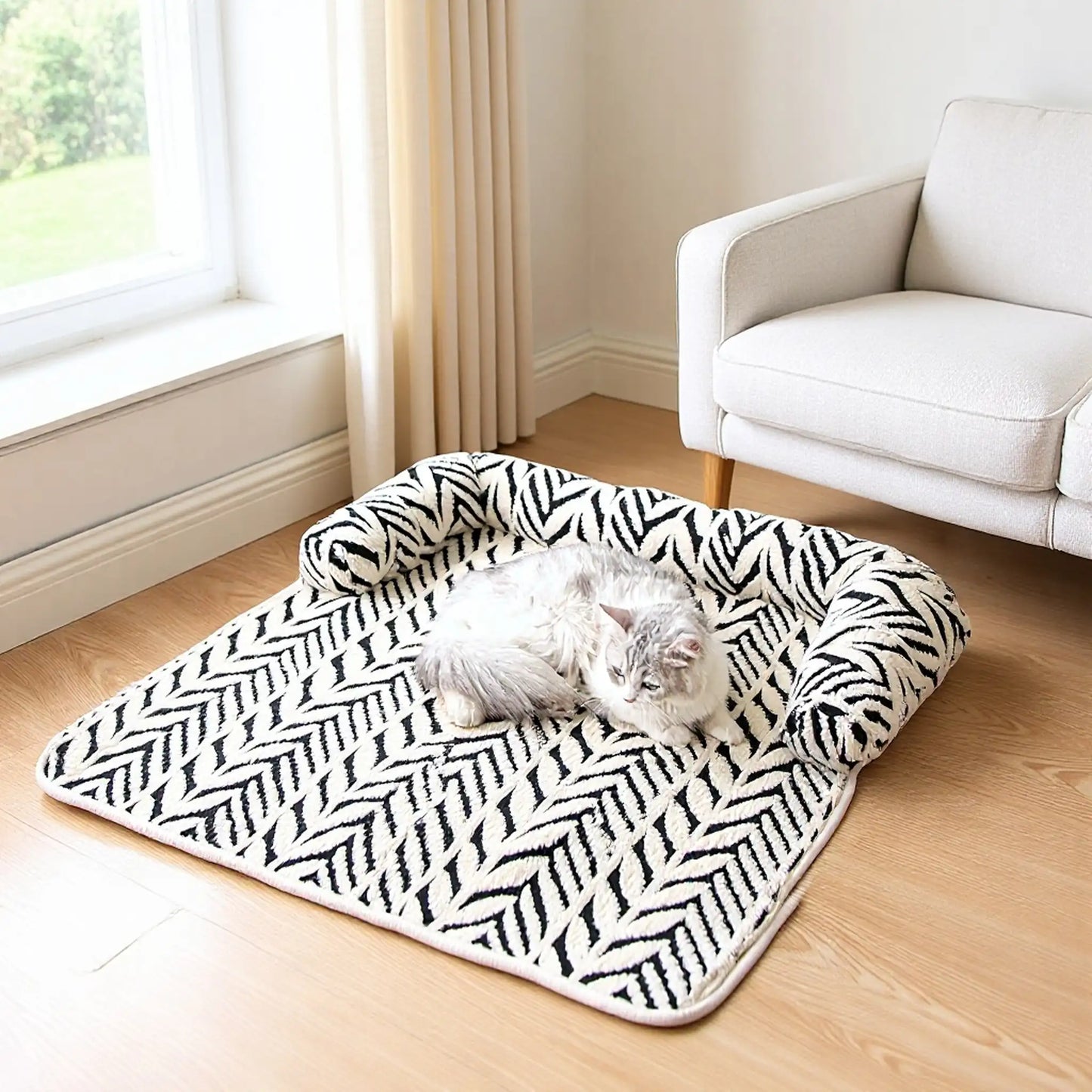 Cat resting on black and white plush sofa pet bed