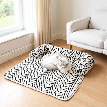 Cat resting on black and white plush sofa pet bed