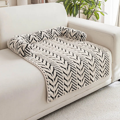 Black and white plush sofa pet bed placed on a sofa
