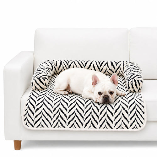 White French Bulldog resting on black and white plush sofa pet bed with raised pillow