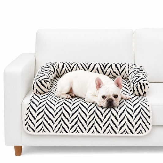 White French Bulldog resting on black and white plush sofa pet bed with raised pillow